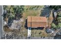 Aerial view of a well maintained single-story home with a brown roof, surrounded by lush greenery and trees at 23940 Oak Ln, Sorrento, FL 32776