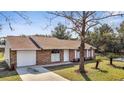 Attractive one story brick home with well kept lawn and white trim, showcasing a welcoming curb appeal at 23940 Oak Ln, Sorrento, FL 32776