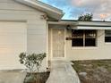 Close-up of the front exterior featuring a security door, awning, and well-kept landscaping at 2525 Ashland Blvd, Orlando, FL 32808