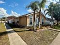 Single-story corner lot featuring neat landscaping, lush green grass, and palm trees in a well-maintained neighborhood at 281 San Gabriel St, Winter Springs, FL 32708