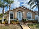 Inviting single-story home with meticulous landscaping and a welcoming front entrance with arched windows and a white door at 281 San Gabriel St, Winter Springs, FL 32708