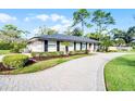 A quaint single-story home with a curved brick pathway, green lawn, and freshly trimmed shrubbery at 322 Nelson Ave, Longwood, FL 32750