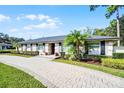 Beautiful single-story home boasting a brick walkway, well-maintained lawn, and decorative palm trees at 322 Nelson Ave, Longwood, FL 32750