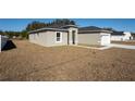 Side view of home featuring minimalist landscaping and a white front door at 325 Marion Oaks Trail, Ocala, FL 34473