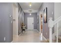 Inviting foyer with decorative wall accents, neutral tile flooring, and stylish lighting at 4157 Lana Ave, Davenport, FL 33897
