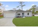 Attractive single-story home with green lawn, neutral paint, blue door, and attached garage at 4944 Tinkham Ave, Orlando, FL 32812