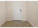 Cozy foyer featuring tile flooring, a white door with smart lock, and neutral-colored walls at 5333 Dragonfly Dr, Wildwood, FL 34785