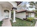 Elegant home entrance featuring a tiled walkway, manicured greenery, and stylish architectural details at 727 Cricklewood Ter, Heathrow, FL 32746