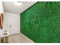 Bright entryway featuring a decorative green wall with Mickey Mouse design, a white door, and a marble-topped table at 7845 Oak Reflection Loop, Davenport, FL 33837