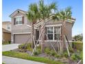 Inviting two-story home with a tile roof, neat landscaping, and young palm trees accenting the front exterior at 7845 Oak Reflection Loop, Davenport, FL 33837