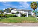 Eye-catching view of the unique home featuring lush landscaping, a well-manicured lawn, and a distinct architectural style at 8922 Bay Cove Ct, Orlando, FL 32819