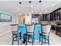 Kitchen island with granite countertops, stainless steel appliances and three pendant lights at 123 Vitoria Rd, Davenport, FL 33837