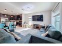 Open-concept living room with tile flooring, kitchen view, and a large gray sectional sofa at 123 Vitoria Rd, Davenport, FL 33837