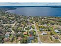 An aerial view of a lakeside neighborhood featuring lush trees, serene water views, and multiple houses at 12442 Sunshine Dr, Clermont, FL 34711