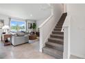 Bright living room featuring a staircase, tile floors, a lake view, and comfortable seating at 1255 Big Bass Dr, Ormond Beach, FL 32174