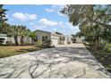 Inviting single-story home with attached garage and carport featuring well-maintained lawn and palm trees at 13201 Plum Lake Cir, Minneola, FL 34715