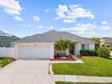 Charming single-story home with a two-car garage, manicured lawn and lush landscaping at 133 Hillcrest Dr, Davenport, FL 33897