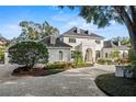 Elegant two-story home with a circular driveway, lush landscaping, and a welcoming entrance, perfect for luxurious living at 1355 S Summerlin Ave, Orlando, FL 32806