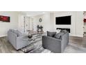 Comfortable living room featuring gray sofas, a glass coffee table, and a modern fireplace with mounted TV above at 2121 5Th Ave, Deland, FL 32724