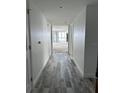 Hallway with wood-look tile leading to an open living area with lots of natural light at 231 Riverside Dr # 1510-1, Daytona Beach, FL 32117