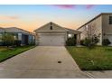 Charming single-Gathering home featuring a two-car garage and well-maintained front lawn at dusk at 2321 Tay Wes Dr, St Cloud, FL 34771