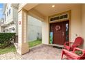 Inviting front porch features brick flooring, decorative columns, and two chairs at 2797 Monticello Way, Kissimmee, FL 34741