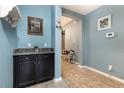 Hallway featuring black cabinet, tiled flooring, and bright blue wall paint at 2797 Monticello Way, Kissimmee, FL 34741