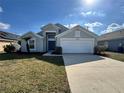 Two-story home with a two-car garage, blue front door, landscaped yard, and well-maintained lawn at 2932 Trema Ave, Winter Haven, FL 33881