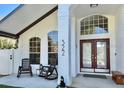 Inviting front entry of a home with rocking chairs and decorative arched windows at 322 N Shadowbay Blvd, Longwood, FL 32779