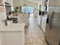 Well-lit kitchen featuring stainless steel appliances, white cabinets, ample counter space, and modern fixtures at 322 N Shadowbay Blvd, Longwood, FL 32779