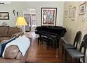 Cozy living area with a piano, leather seating, and natural light, perfect for entertaining and relaxation at 322 N Shadowbay Blvd, Longwood, FL 32779