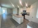 Modern kitchen with granite countertops, stainless steel appliances, and an island at 3623 Marlbrry Way, Sanford, FL 32773