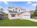 Charming two-story home with an attached two-car garage and neatly manicured lawn on a partly cloudy day at 3778 Martin St, Orlando, FL 32806