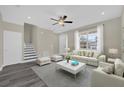 Bright living room with a ceiling fan, a gray rug and a matching comfy white sofa and side chairs at 3778 Martin St, Orlando, FL 32806