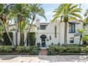 Charming two-story home boasting a red tile roof, lush landscaping, and mature palm trees at 400 W Par St, Orlando, FL 32804