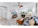 Cozy living room with hardwood floors, a fireplace, a ceiling fan, and ample natural light at 5219 Hammock Cir, St Cloud, FL 34771