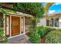 Up-close view of a stunning wooden front door surrounded by lush greenery and stone accents at 533 Balmoral Rd, Winter Park, FL 32789