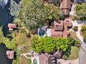 Aerial view of a home with a backyard pool, private dock, and waterfront access to a serene lake at 7496 Lake Marsha Dr, Orlando, FL 32819