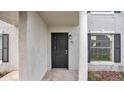 Exterior front entry featuring a black door, textured walls, and dark shutters at 7636 Forest City Rd # F/70, Orlando, FL 32810