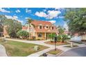 An exterior view of a charming two-story home showing the driveway, manicured lawn, and a red tile roof at 7655 Debeaubien Dr, Orlando, FL 32835