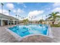 Large community pool with palm trees, lounge chairs, and a clubhouse under a sunny sky at 8168 Boat Hook Loop # 707, Windermere, FL 34786