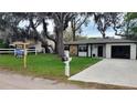 A lovely home featuring a well-maintained lawn and mature trees, alongside a 'For Sale' sign at 11801 Lake Susan Ct, Clermont, FL 34711