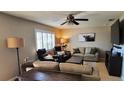 Cozy living room boasting tile flooring, a ceiling fan, and neutral paint, creating a warm and inviting atmosphere at 11801 Lake Susan Ct, Clermont, FL 34711