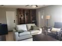 Comfortable living room with a rustic built-in bookcase, neutral sofa, and tile flooring at 11801 Lake Susan Ct, Clermont, FL 34711