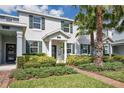 Inviting townhouse with lush landscaping, brick walkway, and palm trees enhancing curb appeal at 11867 Pulitzer Pl, Orlando, FL 32832