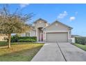 Inviting front exterior of a home with a well-maintained lawn and attached two-car garage at 15506 Gemini Dr, Mascotte, FL 34753