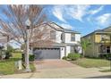 Charming two-story home with a gray roof, a two-car garage, and a well-maintained lawn at 2383 Victoria Dr, Davenport, FL 33837