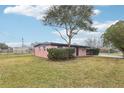 Cozy brick home featuring a well-manicured lawn, mature trees and an attached carport on a sunny day at 2934 Truman Blvd, Sanford, FL 32771