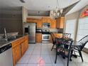 Eat-in kitchen featuring stainless steel appliances, tile flooring, wood cabinets, and breakfast table at 459 Wood Rose Ln, Altamonte Springs, FL 32714