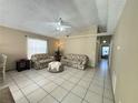 Bright living room featuring tile floors, ceiling fan, and comfortable seating at 459 Wood Rose Ln, Altamonte Springs, FL 32714